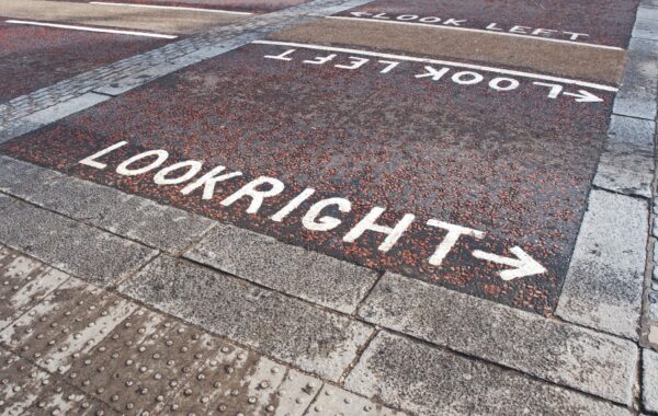 A pedestrian showing the road markings "Look right" and "Look left"