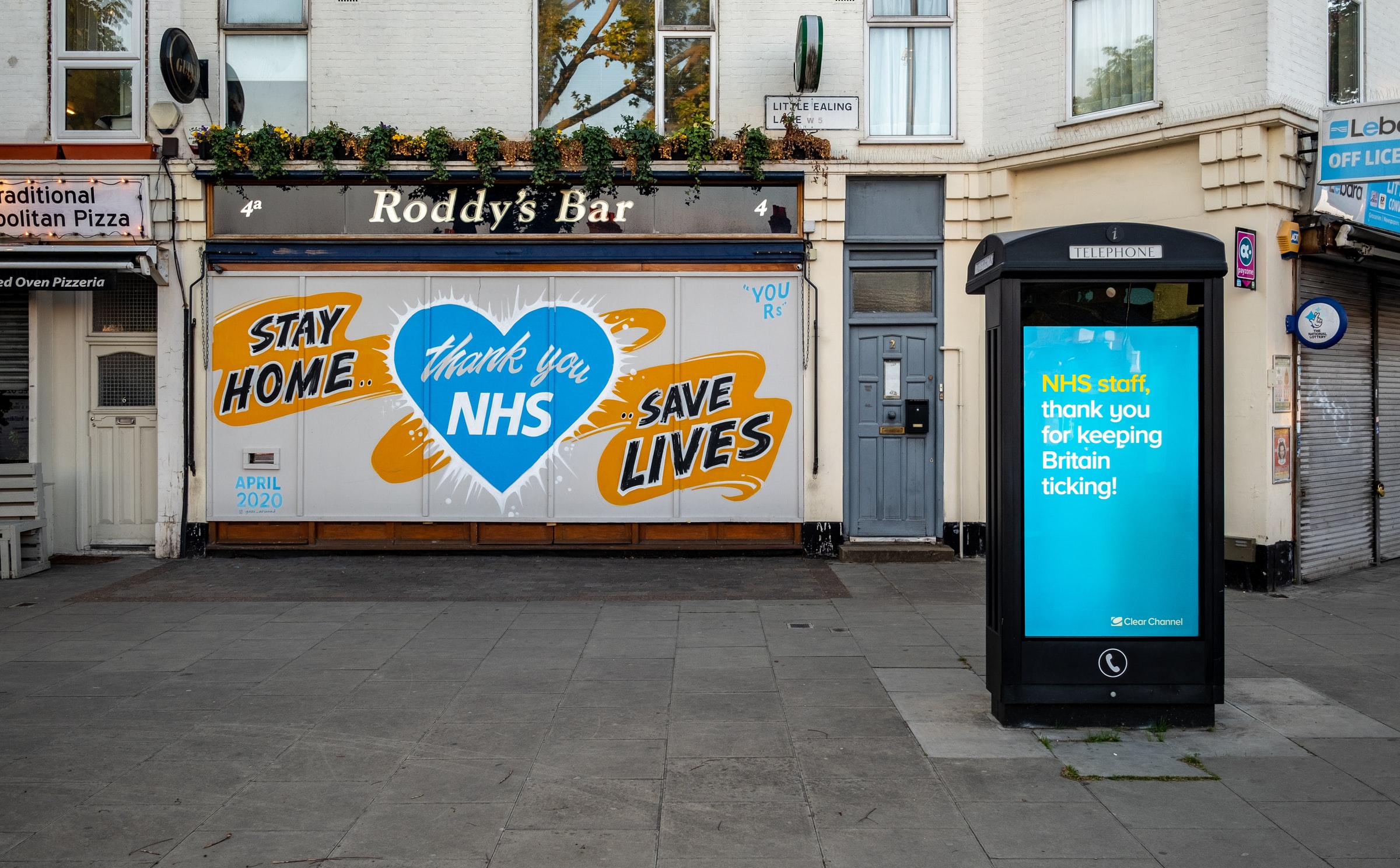 A shop front in Ealing in May 2020, showing a brightly-coloured painted message "Thank you NHS. Stay Home. Save Lives."
