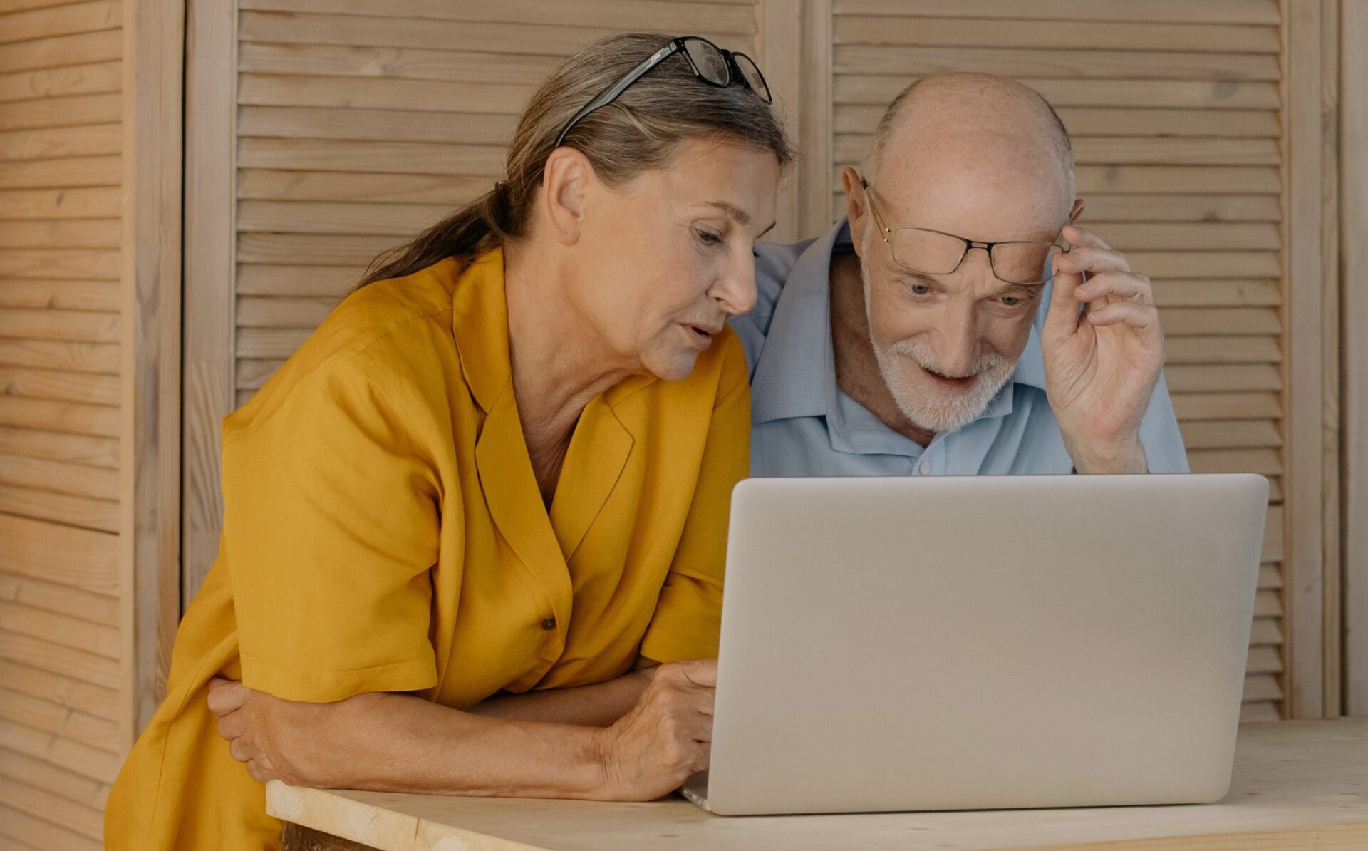 Woman showing man something on a laptop screen